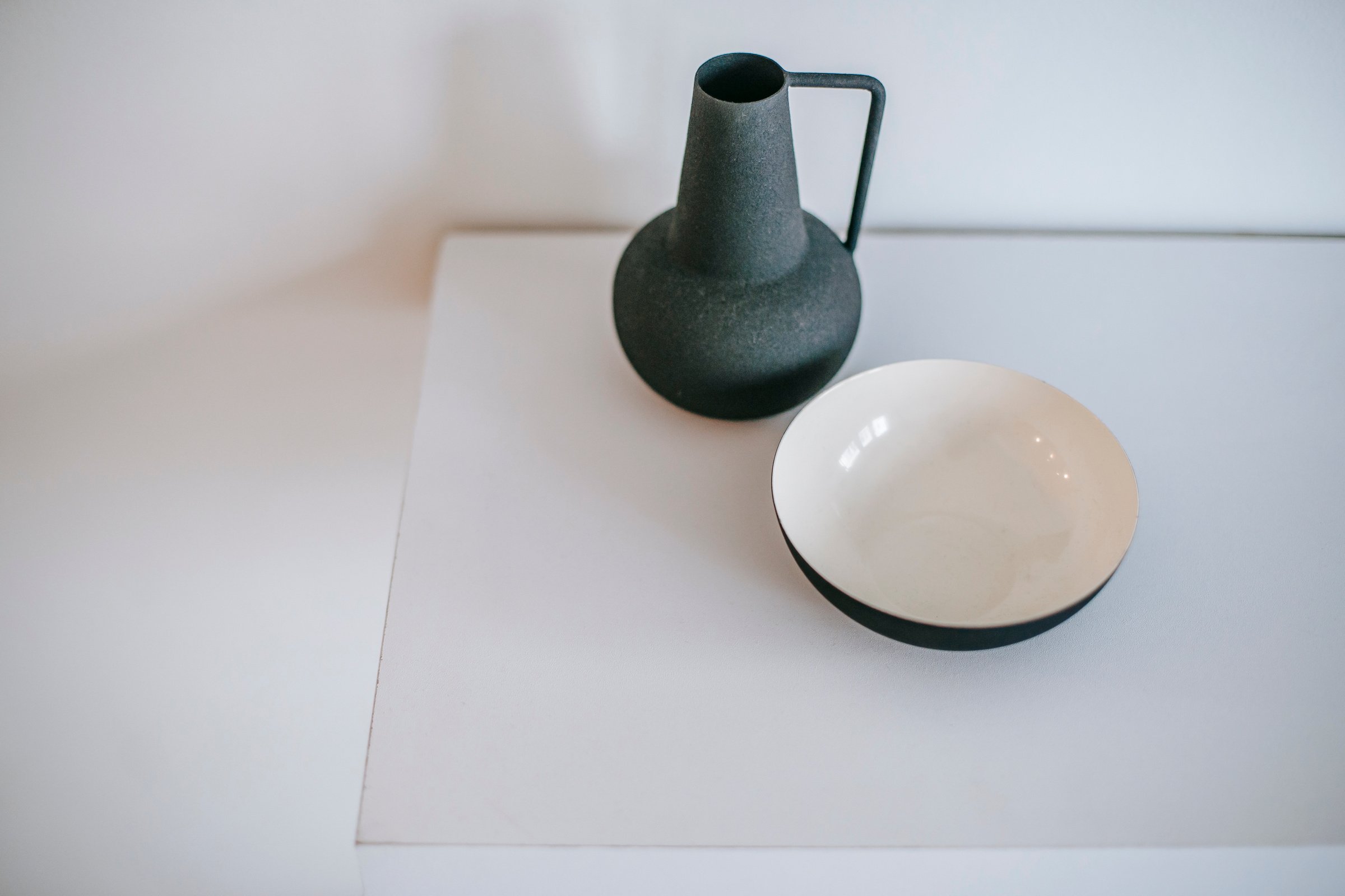 Decorative vase near ceramic bowl on table